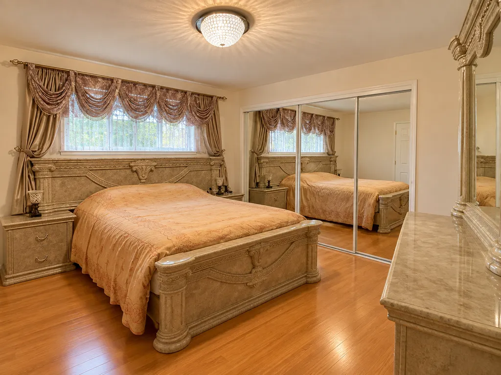 A bedroom with a wooden bed, nightstands, and a large mirror.